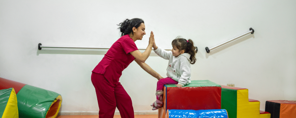 Terapeuta jugando con una niña en un entorno seguro y divertido